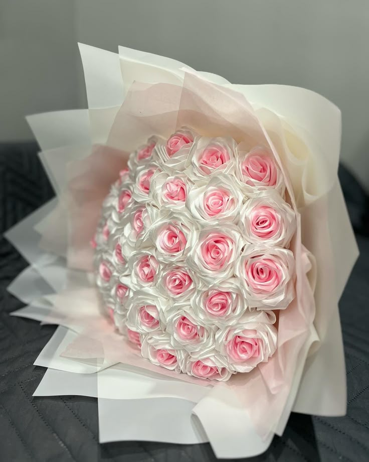 A styled ribbon rose bouquet with soft pink centers and white outer petals