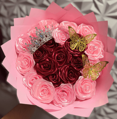 Pink and red rose heart shaped bouquet wrapped in pink with a silver tiara and gold butterflies